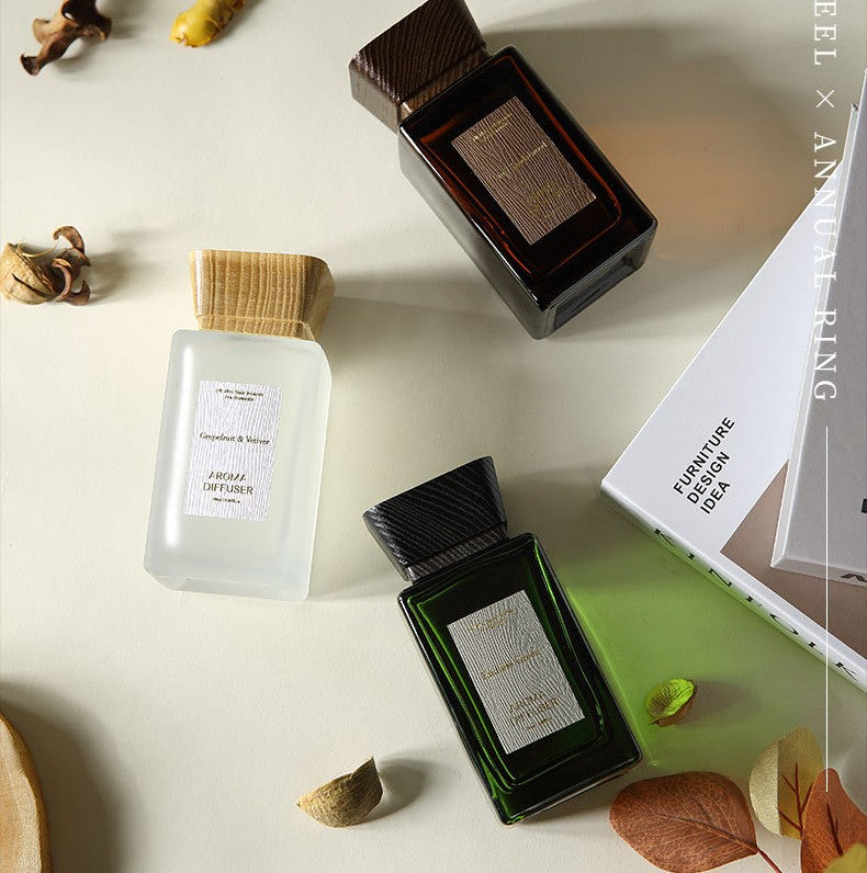 Three perfume bottles on a light surface with decorative elements