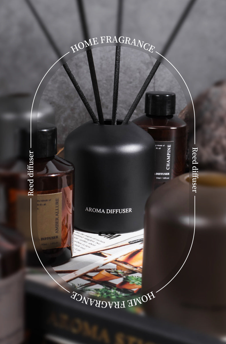 Black aroma diffuser with reeds and bottles on a blurred background