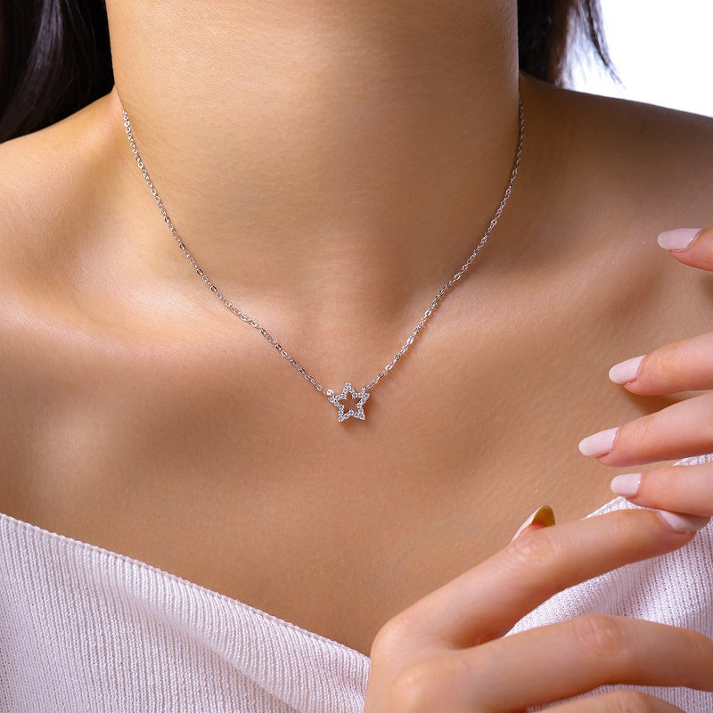Silver necklace with a star-shaped pendant on a model against a neutral background