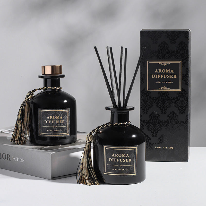Two black aroma diffusers with decorative elements on a gray background