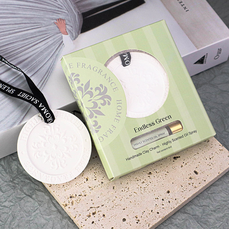 Green packaging of a home fragrance product on a textured surface