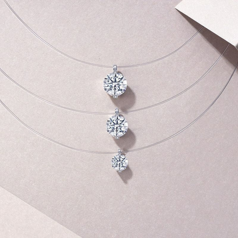 Three diamond earrings on a light pink background
