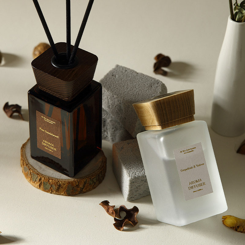 Aromatherapy diffuser set with wooden base and white bottle on a neutral background