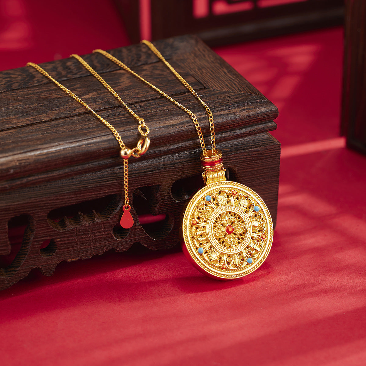 Silver necklace with a decorative pendant on a wooden stand against a red background