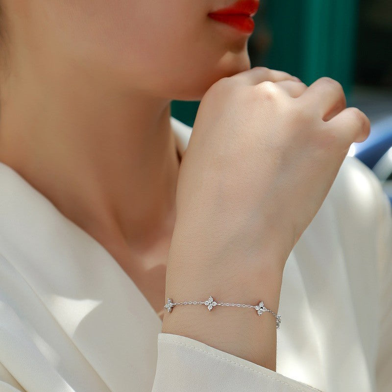 Close-up of a person wearing a delicate silver bracelet with a blurred background