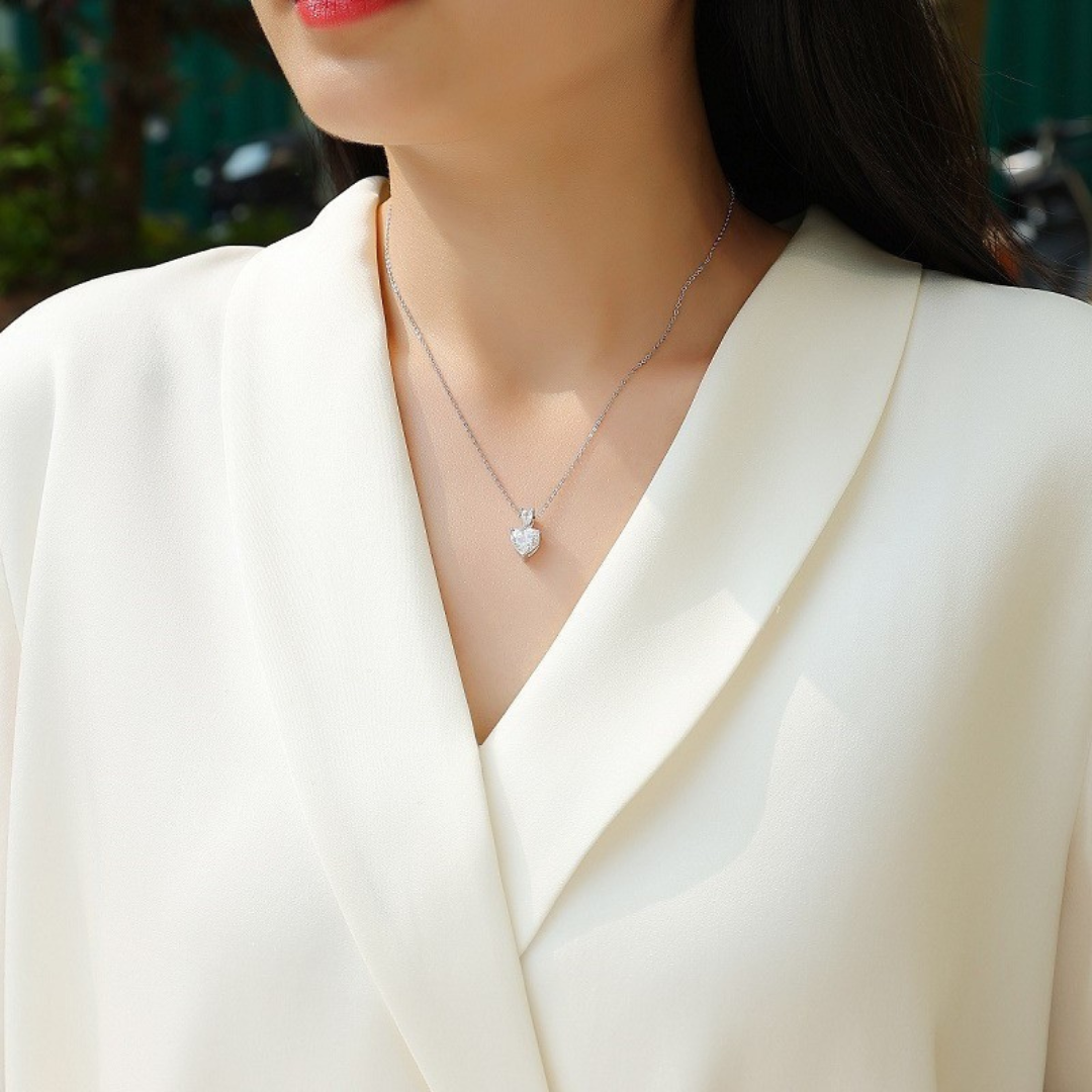 Woman wearing a silver necklace with a pendant against a blurred background