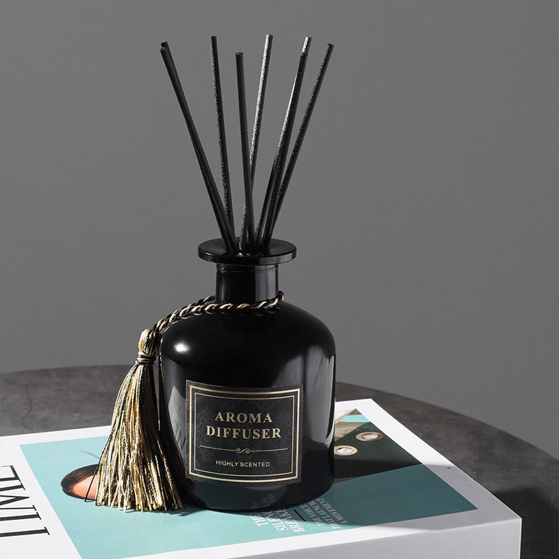 Black aroma diffuser with reeds on a gray surface