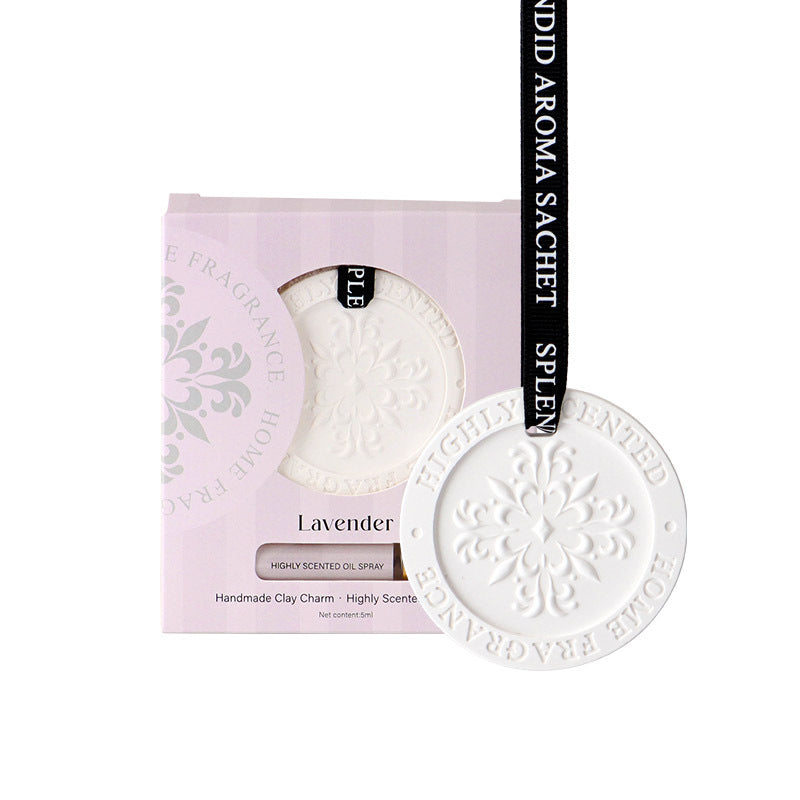 White clay charm with 'Fragrance House' branding on a pink packaging background.