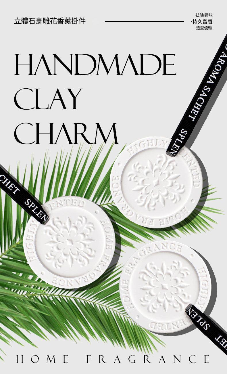 Handmade clay charm with green leaves and branding text on a white background
