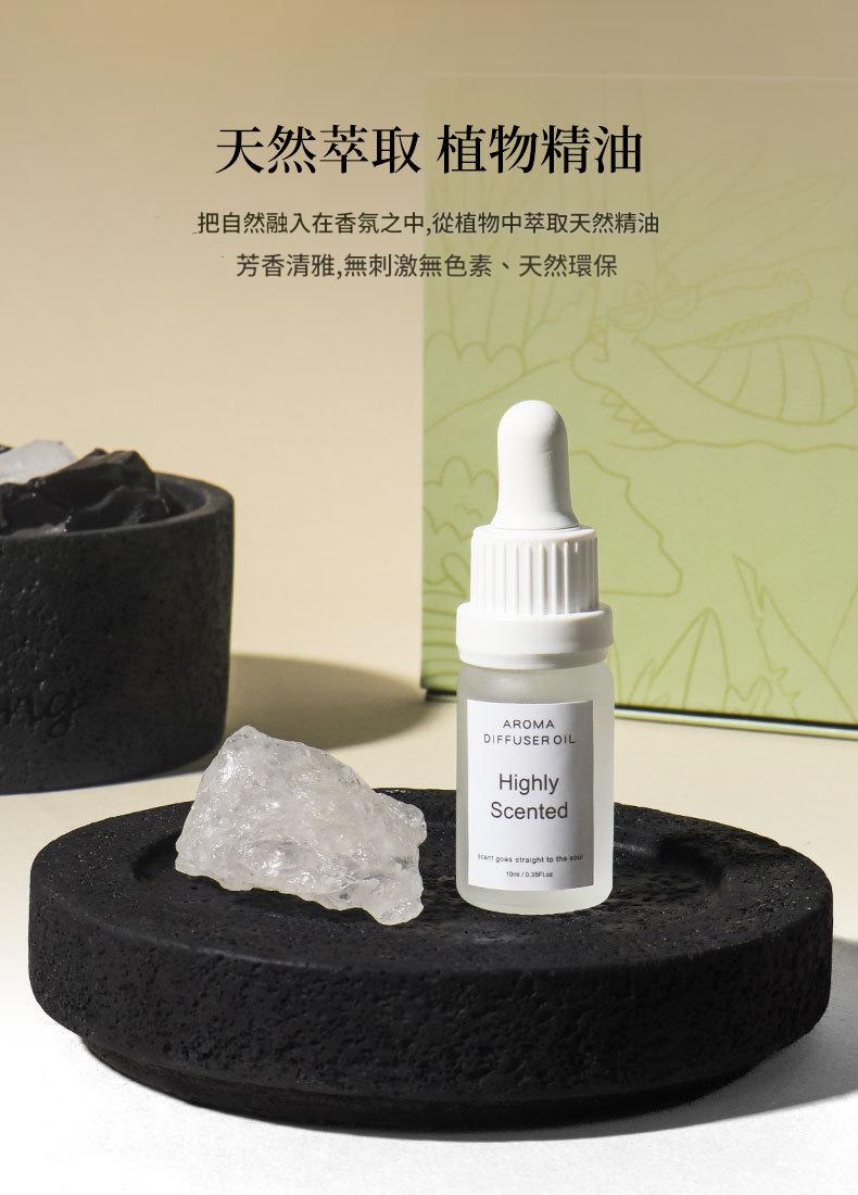 Aromatherapy diffuser oil bottle on a black stone surface with a green box in the background.