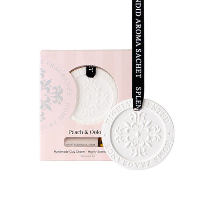 White ceramic charm with 'Peach & Oolo' branding on a pink packaging background
