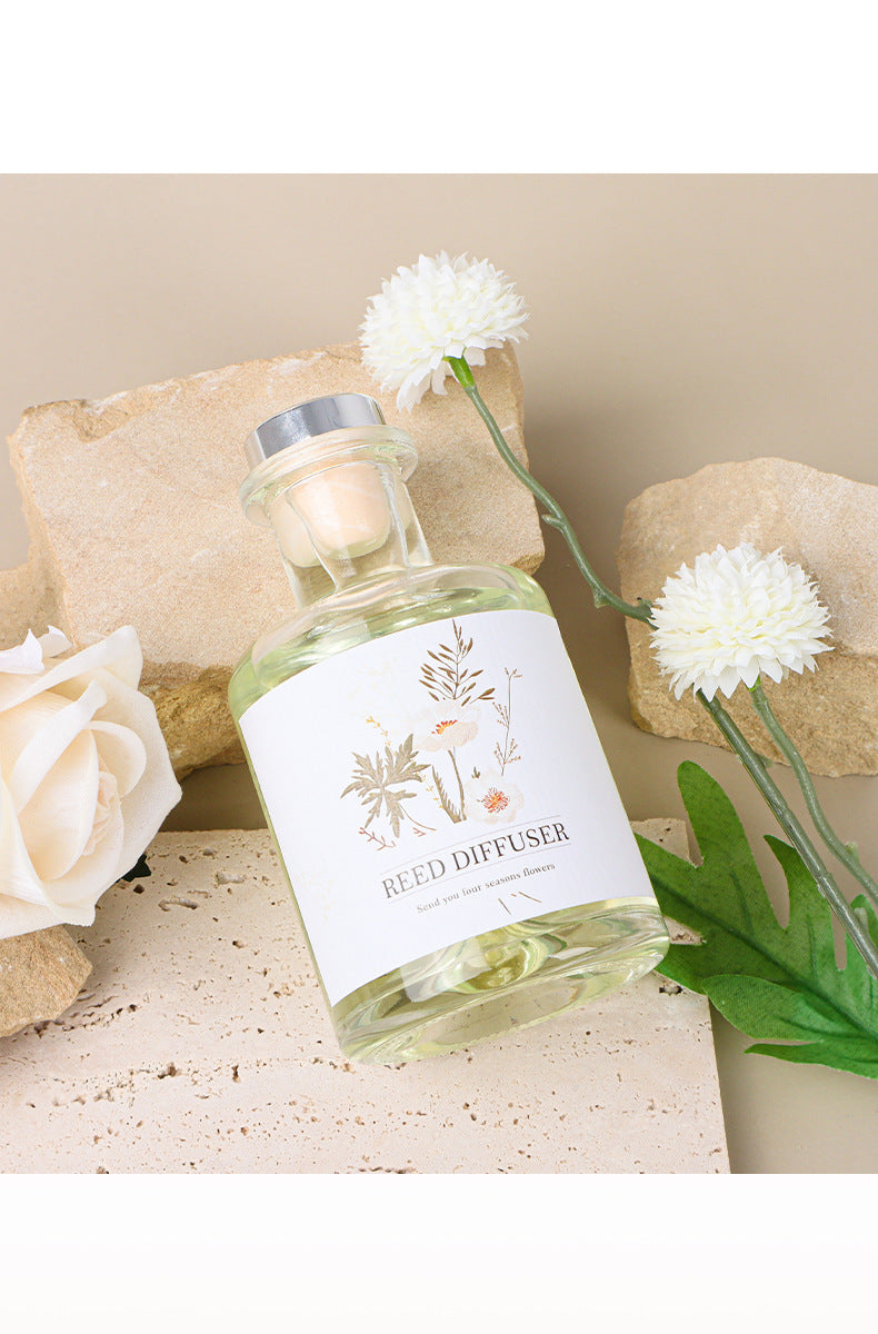 Bottle of Reed Diffuser with flowers on a stone surface