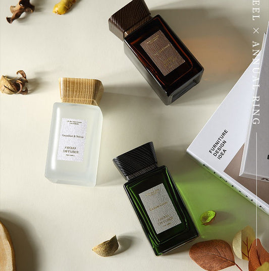 Three perfume bottles on a light surface with decorative elements