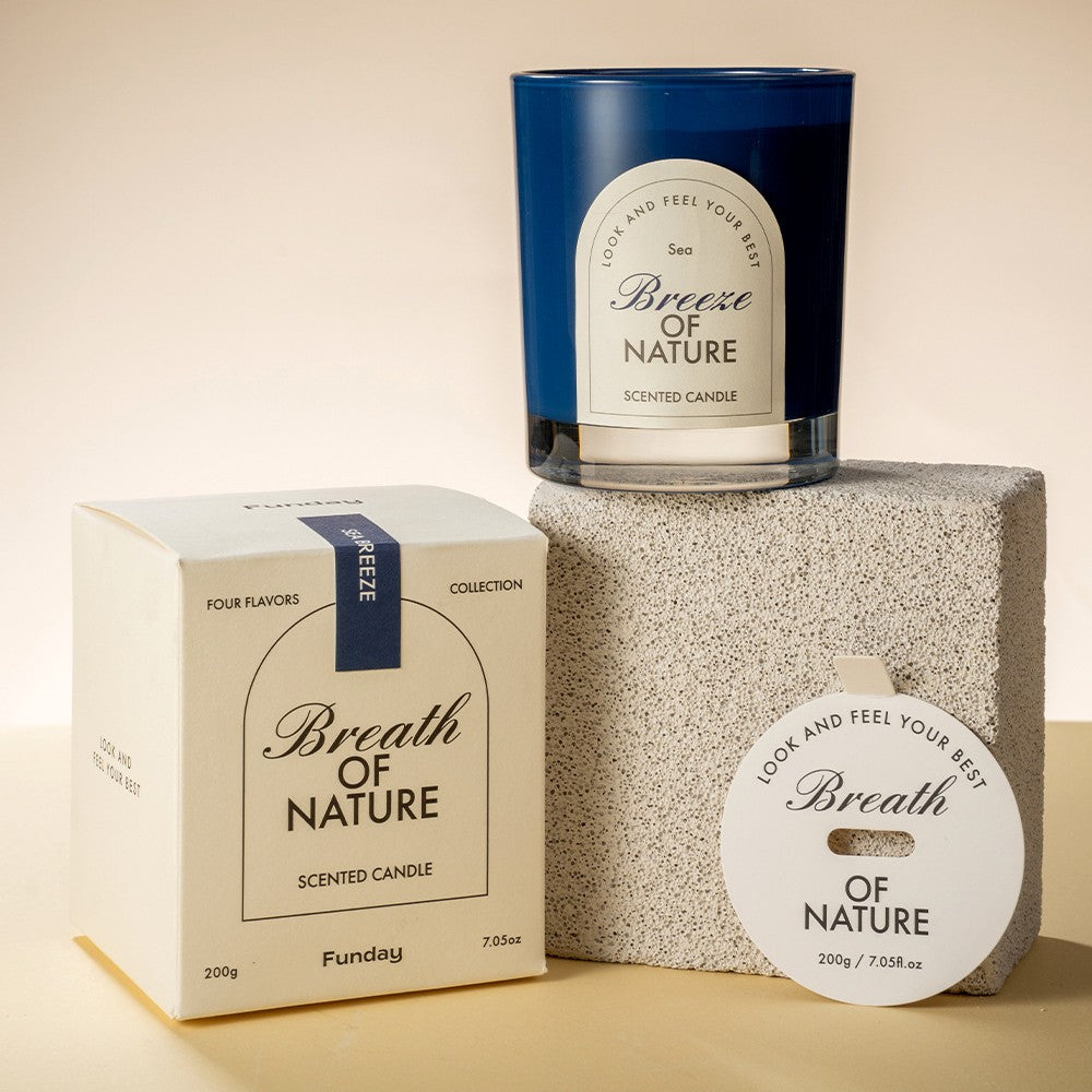 Scented candle with packaging and decorative item on a beige background