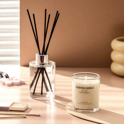 Scented candle and diffuser on a table with a neutral background