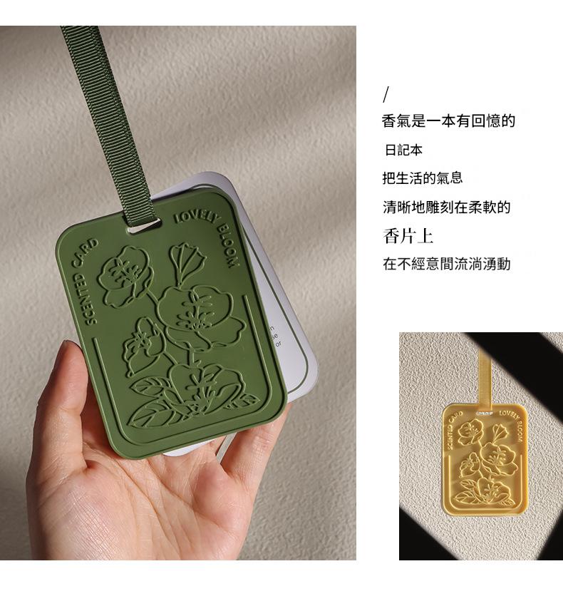 Green floral embossed tag held by a hand with text on a beige background