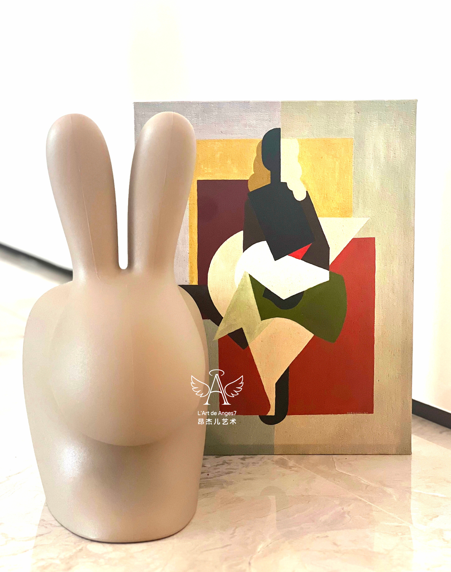 Beige rabbit-shaped object on a surface with abstract art in the background