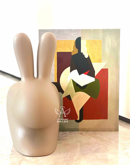 Beige rabbit-shaped object on a surface with abstract art in the background