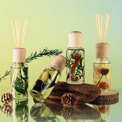 Set of diffuser bottles with natural elements on a reflective surface with a green gradient background