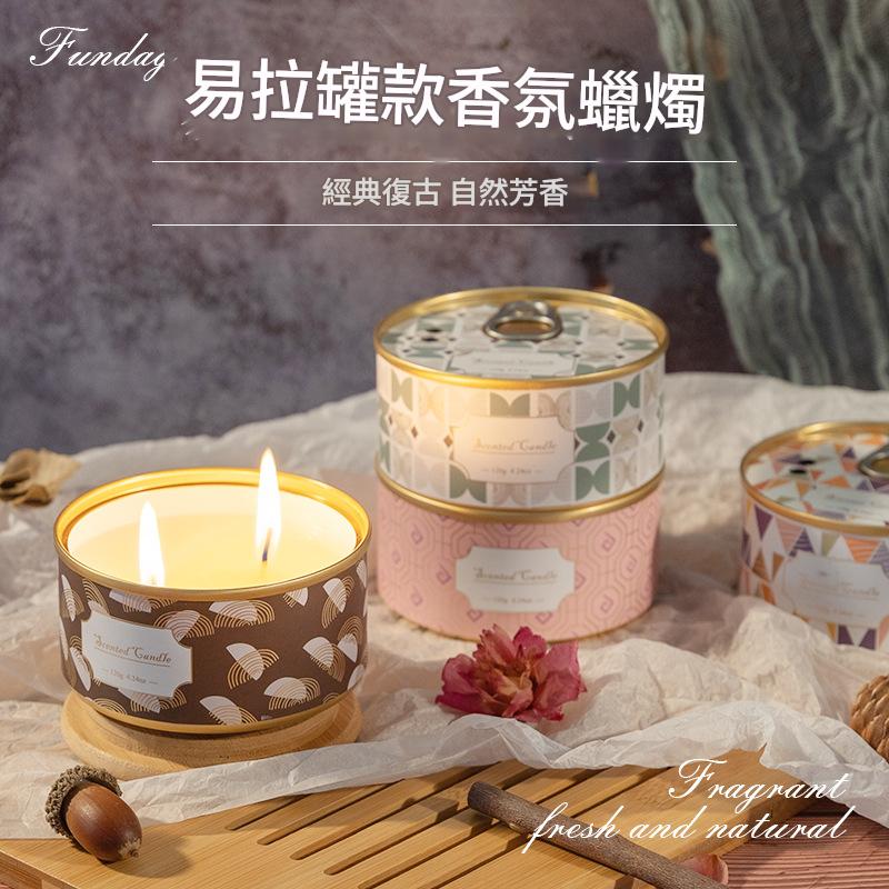 Fragrant candles with decorative lids on a wooden surface, featuring text and branding.
