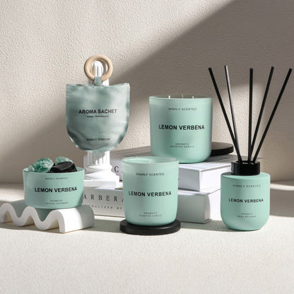 Collection of Aroma Sachet products including candles and diffusers on a neutral background