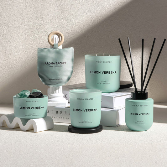 Collection of Aroma Sachet products including candles and diffusers on a neutral background