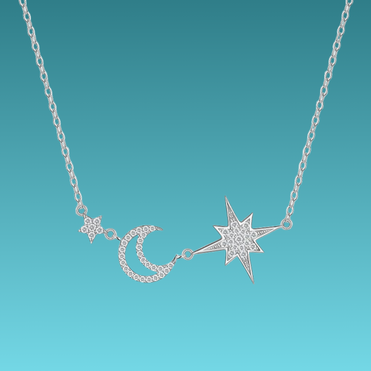 Silver necklace with star, moon, and flower pendants on a teal background