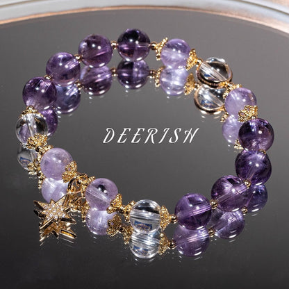 Purple beaded bracelet with gold accents on a reflective surface, featuring the brand 'DEERISW'.