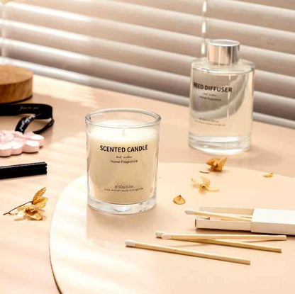 Scented candle and diffuser on a table with decorative elements