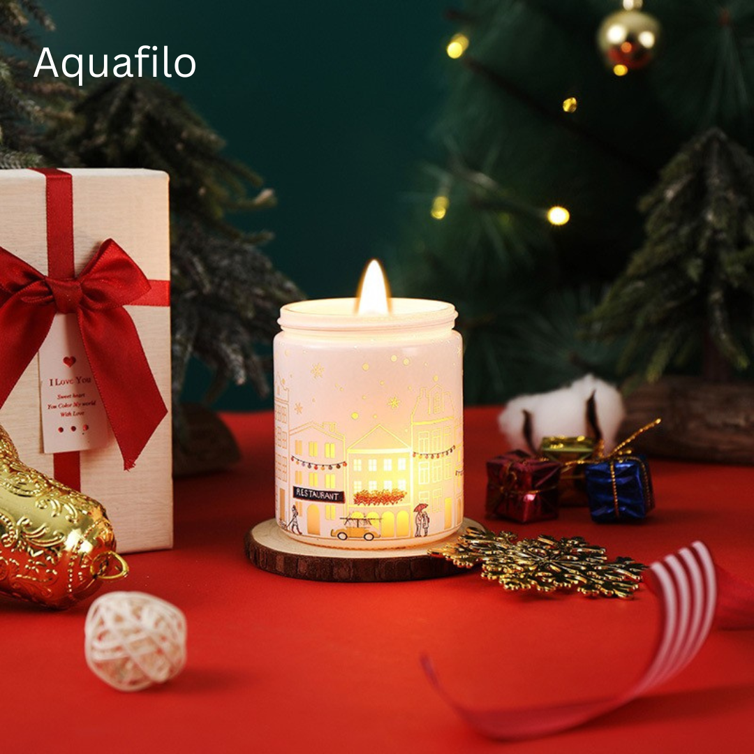 Decorative candle with Christmas-themed packaging and decorations on a red surface.