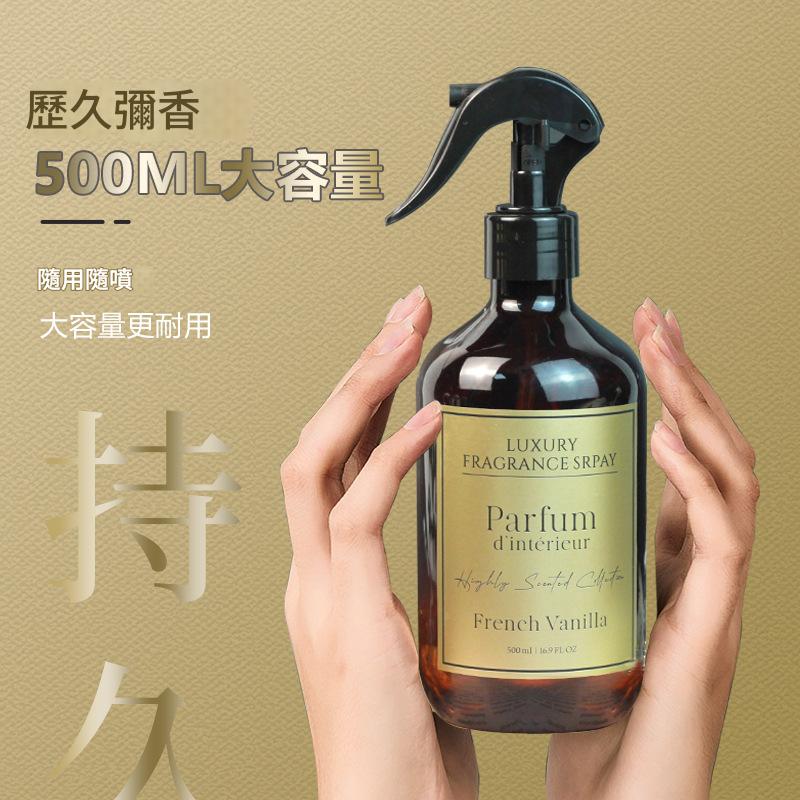 Brown spray bottle labeled 'Parfum d'intérieur' held by hands against a gold background with text.