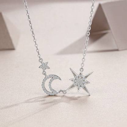 Silver necklace with star and moon pendants on a light background