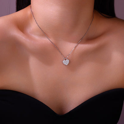 Necklace with a heart-shaped pendant on a person against a dark background