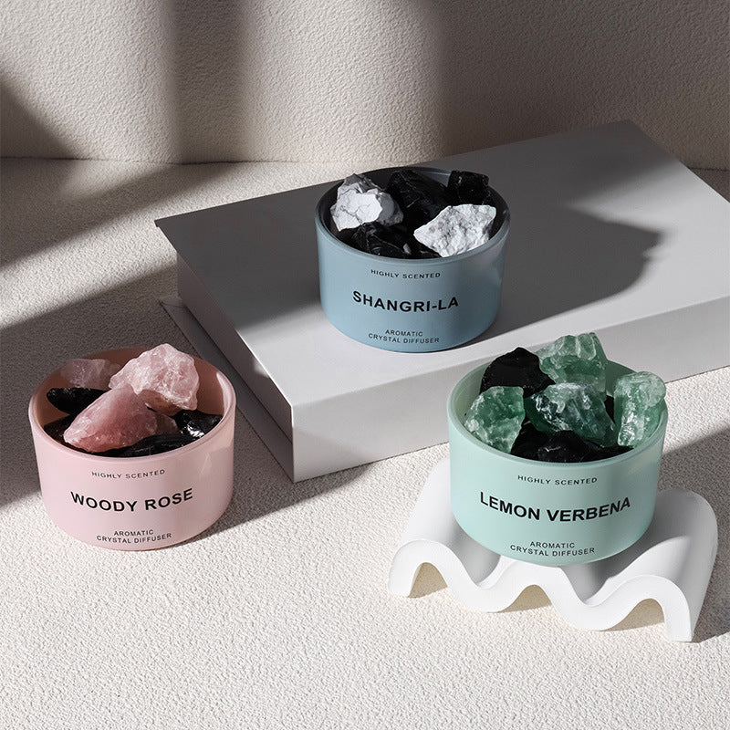 Three crystal diffusers with different scents on a light surface.