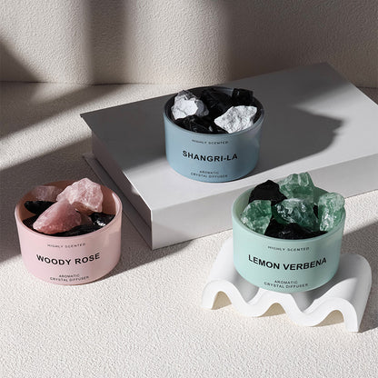 Three crystal diffusers with different scents on a light surface.