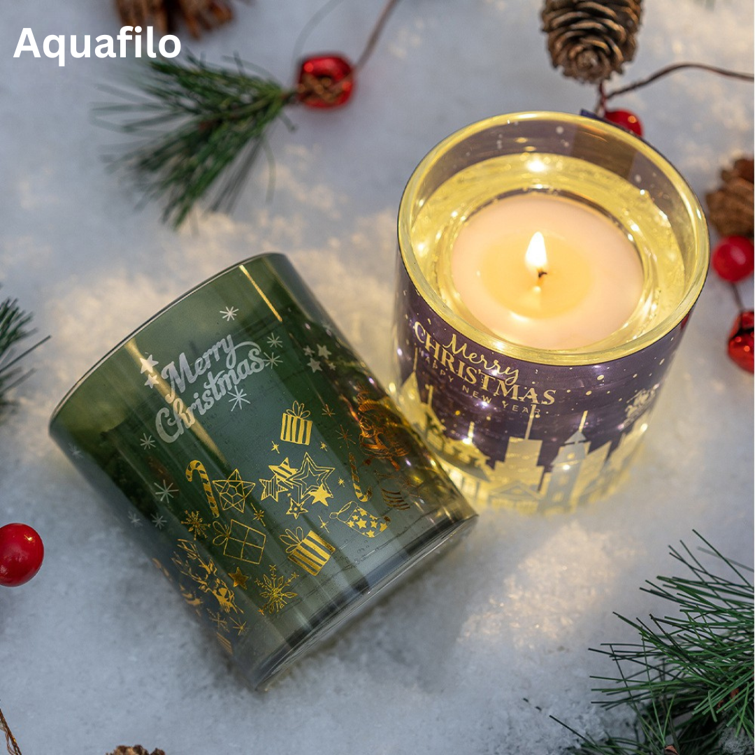 Two Christmas-themed candles on a snowy surface with decorative elements.