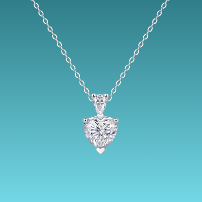 Heart-shaped diamond pendant on a chain against a teal background