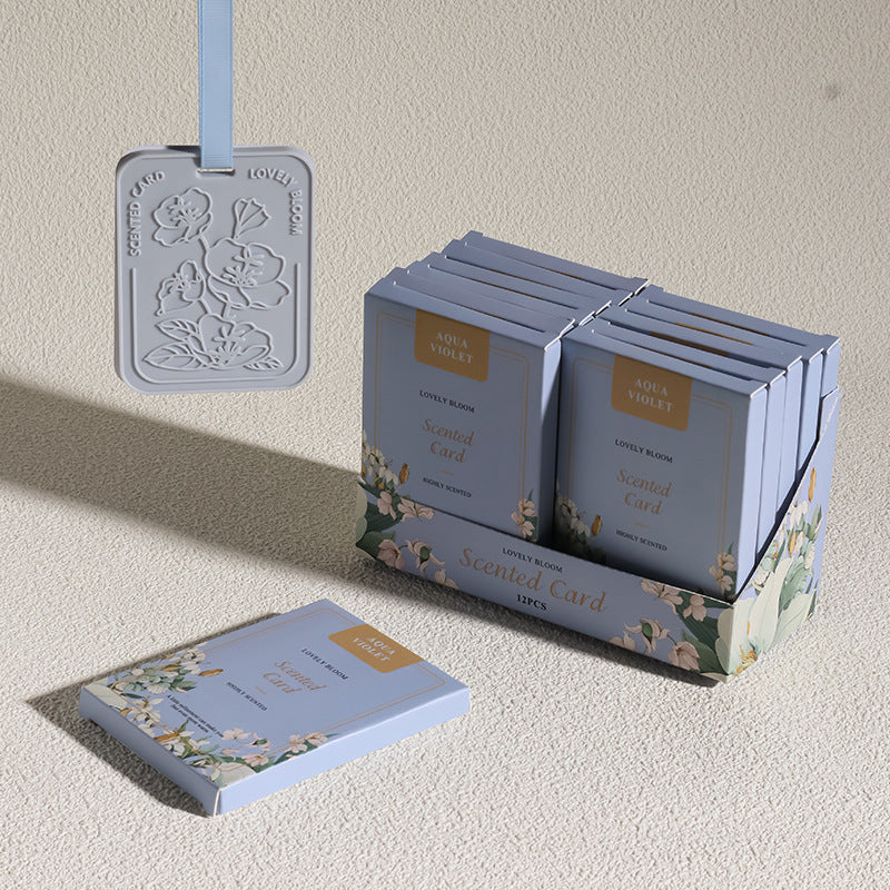 Scented cards with floral design on a beige surface