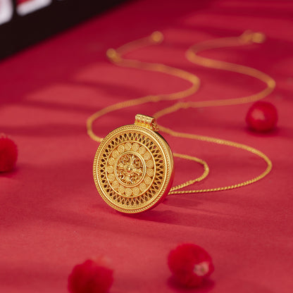 Gold necklace with a decorative pendant on a red background