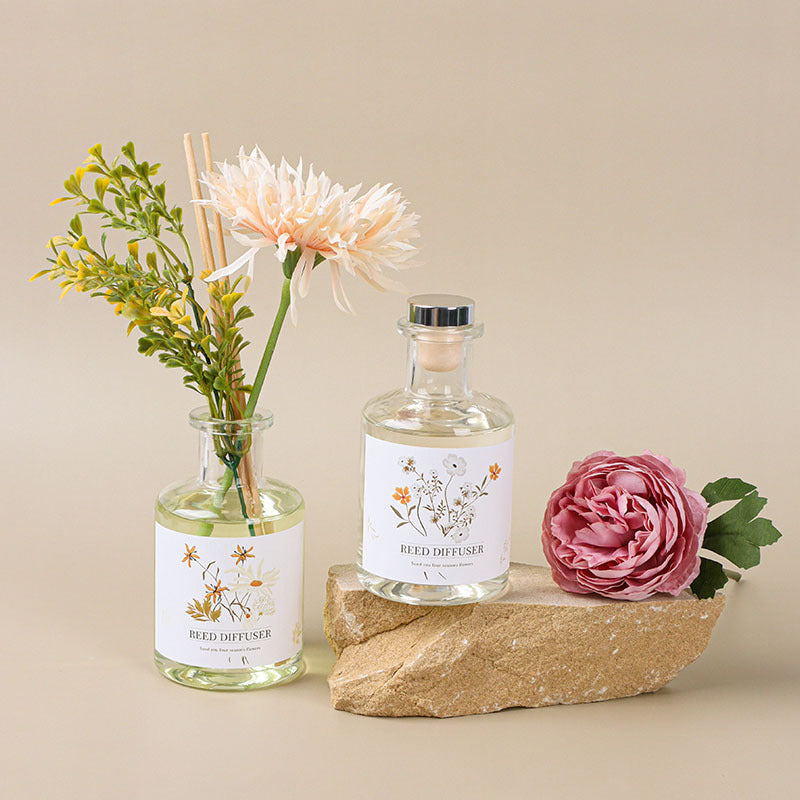 Reed diffuser with floral elements on a beige background