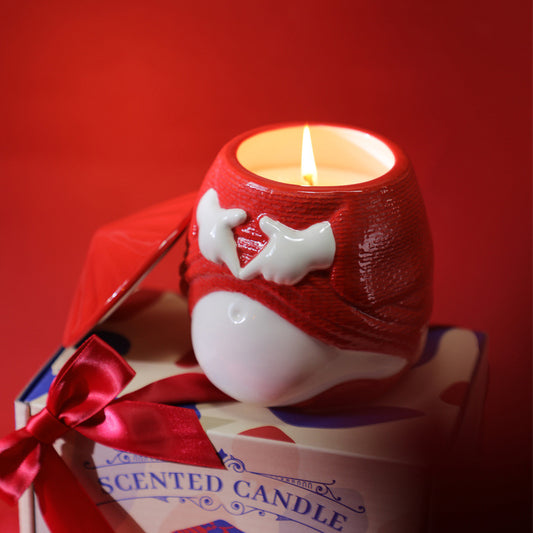 Scented candle in a red holder with a bow on a red background
