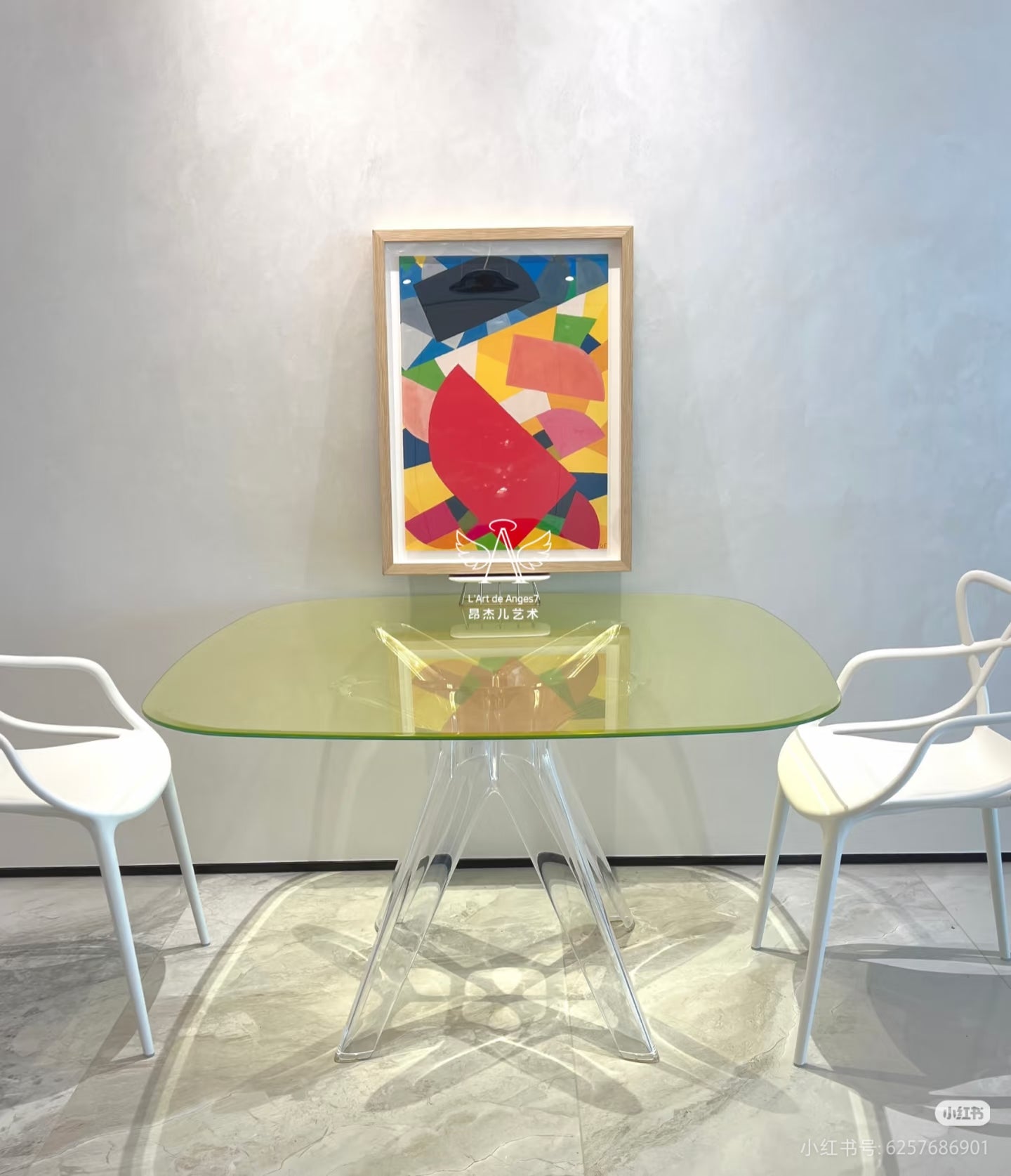 Modern glass dining table with white chairs and a colorful abstract painting on the wall.