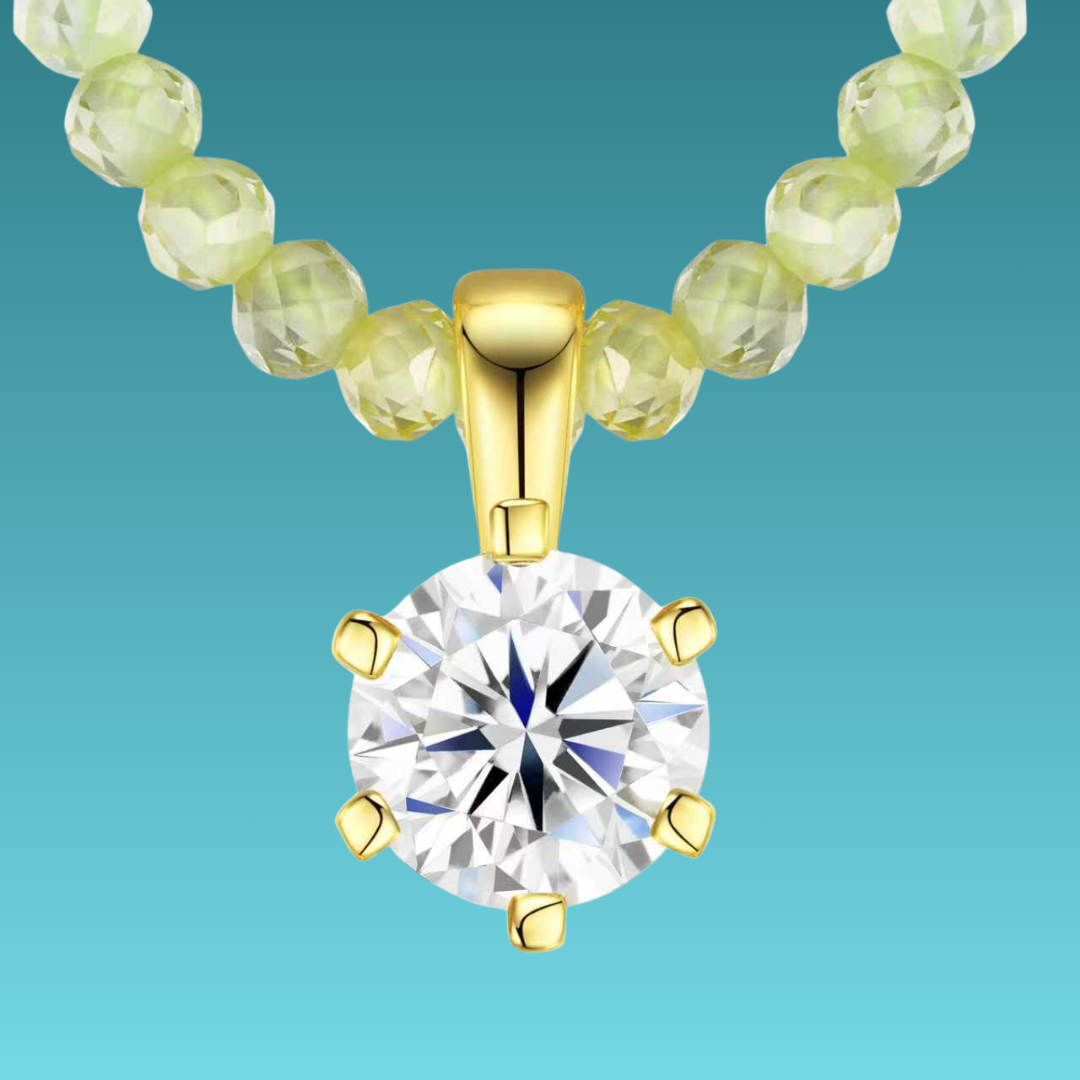 Gold necklace with a round diamond pendant on a teal background
