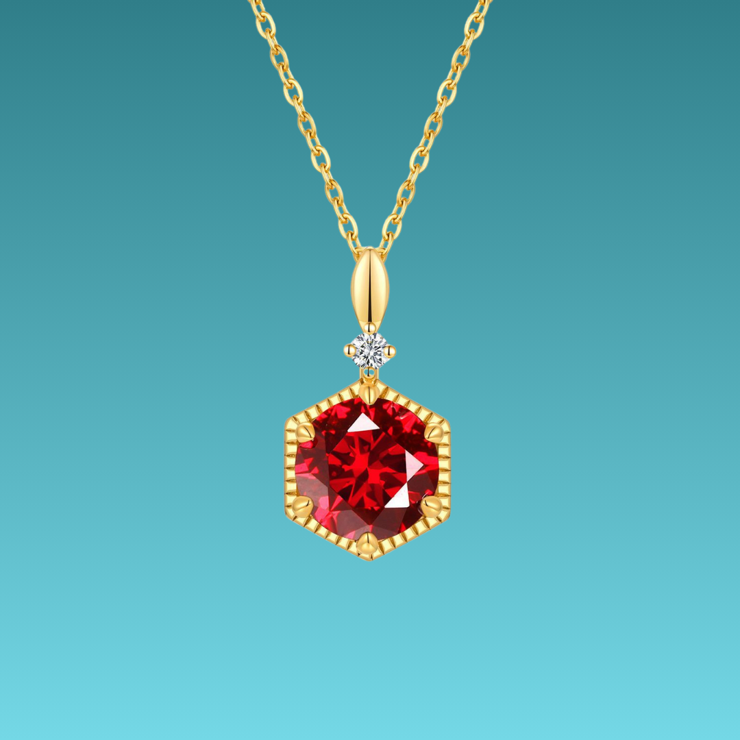 Gold necklace with a red gemstone pendant on a teal background