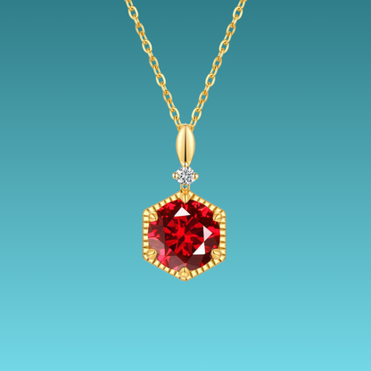 Gold necklace with a red gemstone pendant on a teal background
