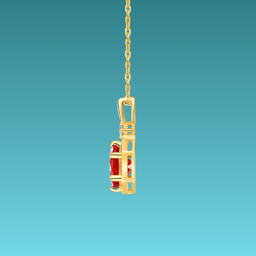 Gold pendant with red gemstone on a blue background