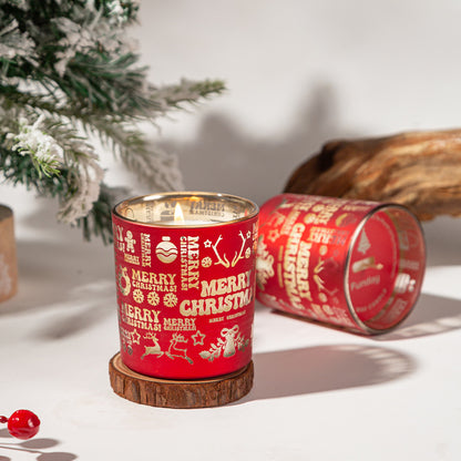 Red Christmas-themed candle with decorative patterns on a white surface with a blurred background
