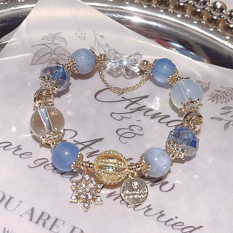 Bracelet with blue beads and gold accents on a decorative paper background