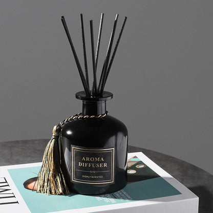 Black aroma diffuser with reeds on a gray surface