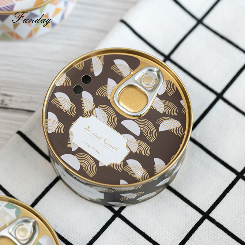 Decorative candle tin with gold and white design on a checkered surface